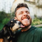 dog licking man's face