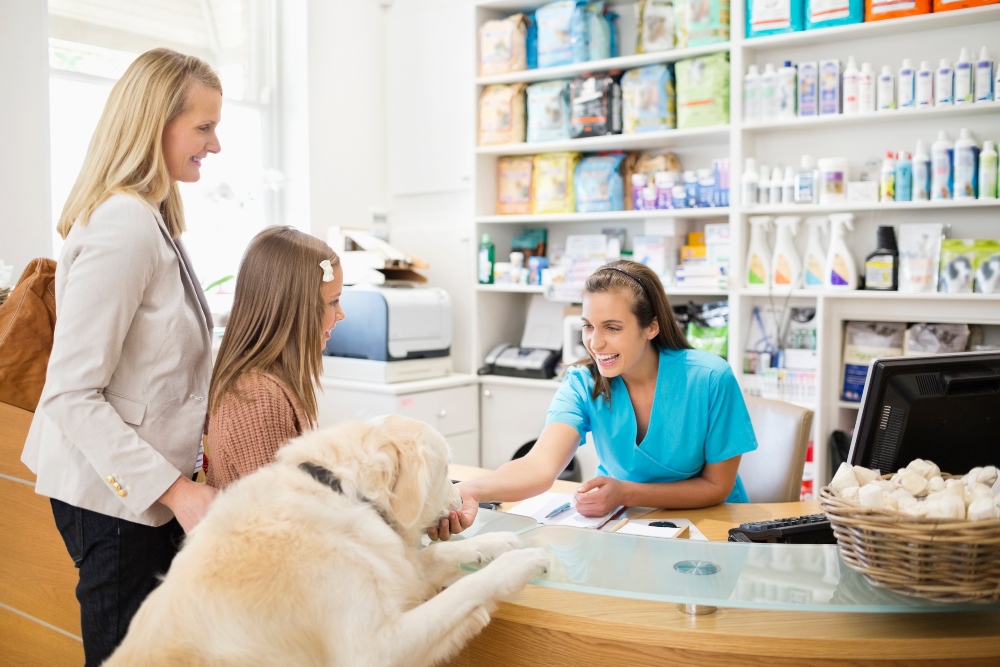 family and dog checking out at veterinary office