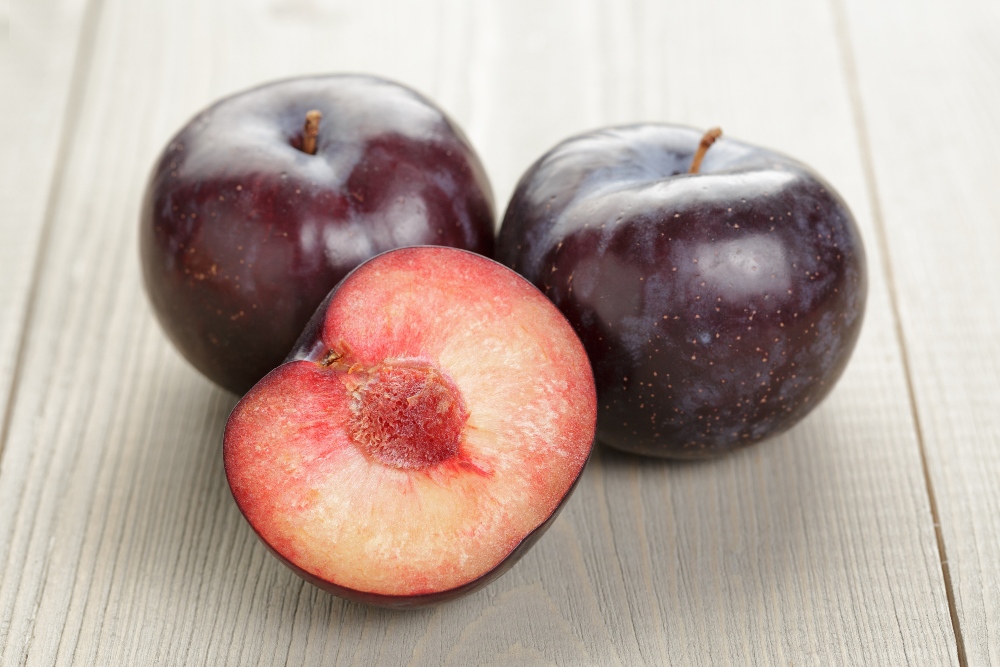 three plums on a table