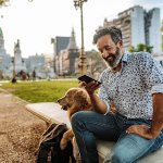 Man at a city park with his dog.